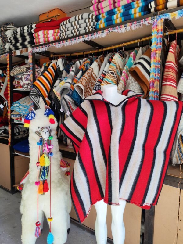 Poncho artesanal doble cara de lana de oveja, tejido en telar tradicional, exhibido en tienda de Salinas de Guaranda.